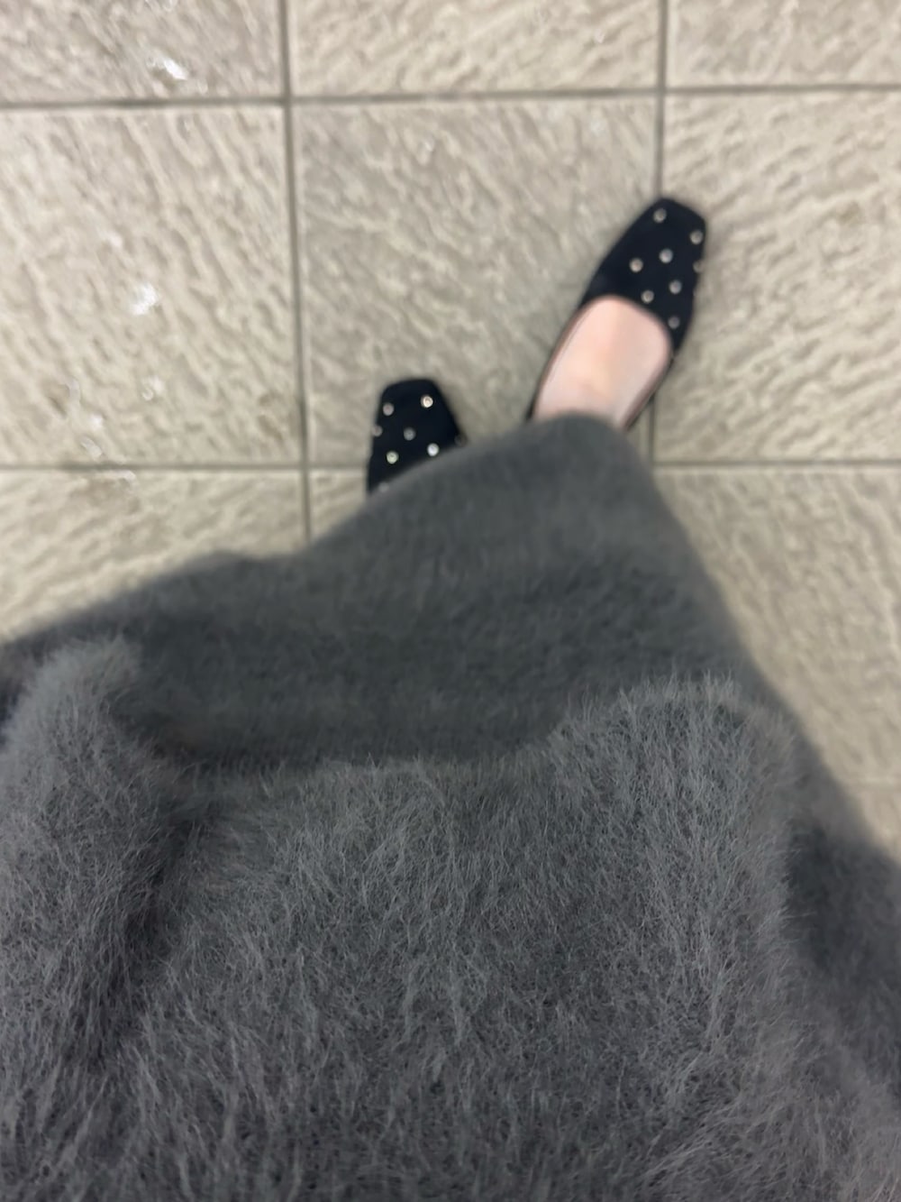 ブラック系のパンプス、グレー系のスカート、ブラウン系のボストンバッグを着用したレディースの秋コーディネートの5枚目の写真