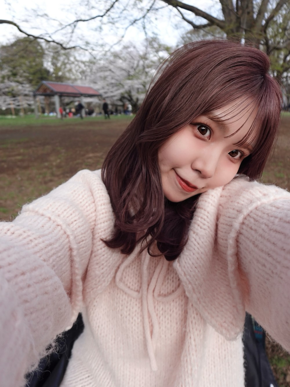 ブラック系のスカート、シルバー系のパンプス、ピンク系のパーカーを着用したレディースの春コーディネートの5枚目の写真