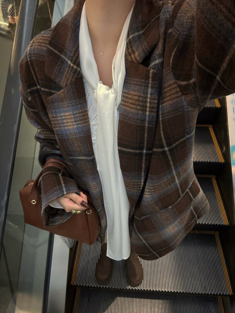 ブラウン系のジャケット/アウター、ホワイト系のシャツ/ブラウス、ブラウン系のボストンバッグを着用したレディースの秋コーディネートの2枚目の写真