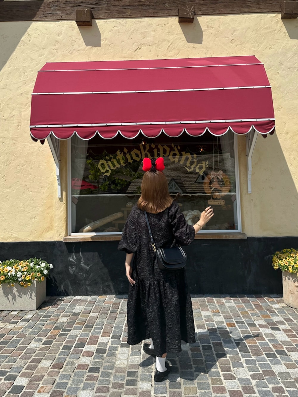 ブラック系のショルダーバッグ、ブラック系のワンピースを着用したレディースの夏コーディネートの2枚目の写真