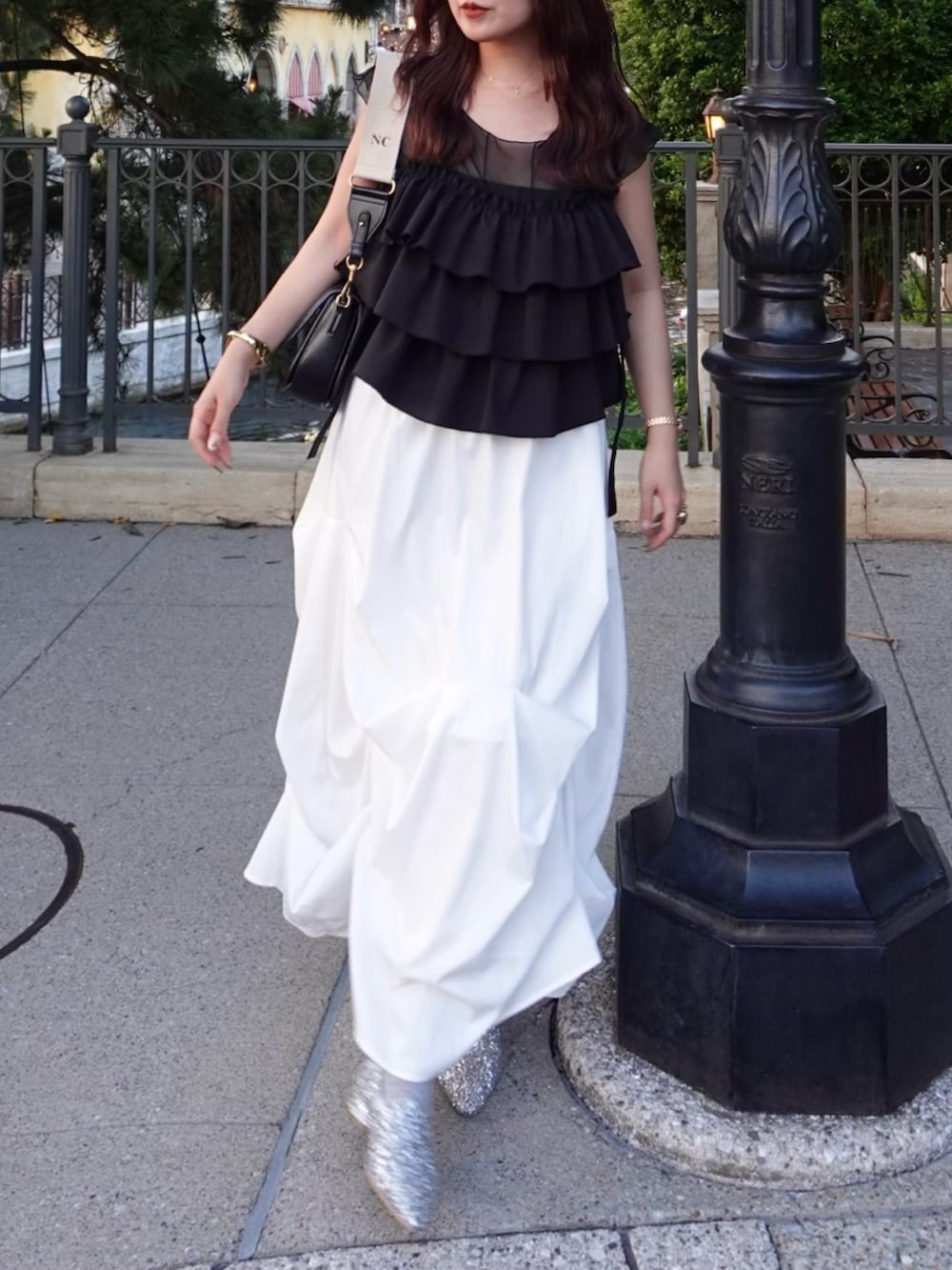 ホワイト系のスカート、シルバー系のローファー、ブラック系のシャツ/ブラウスを着用したレディースの夏コーディネートの4枚目の写真