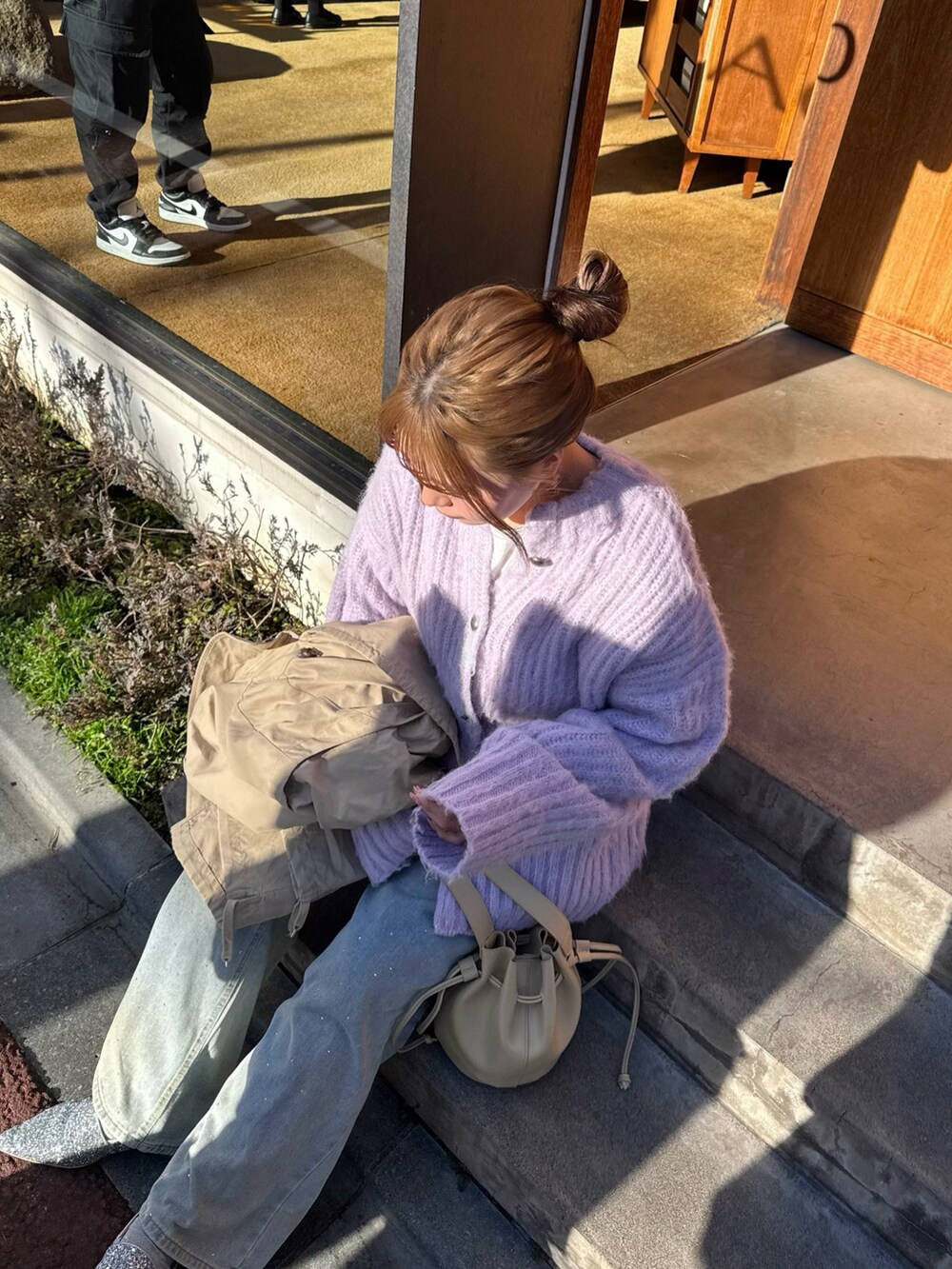 ベージュ系のベスト、パープル系のカーディガン/ボレロ、ベージュ系のショルダーバッグを着用したレディースの春コーディネートの3枚目の写真