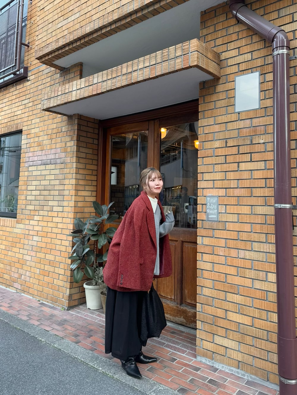 ブラック系のトートバッグ、ブラック系のブーツ、グレー系のニット/セーターを着用したレディースの春コーディネートの4枚目の写真