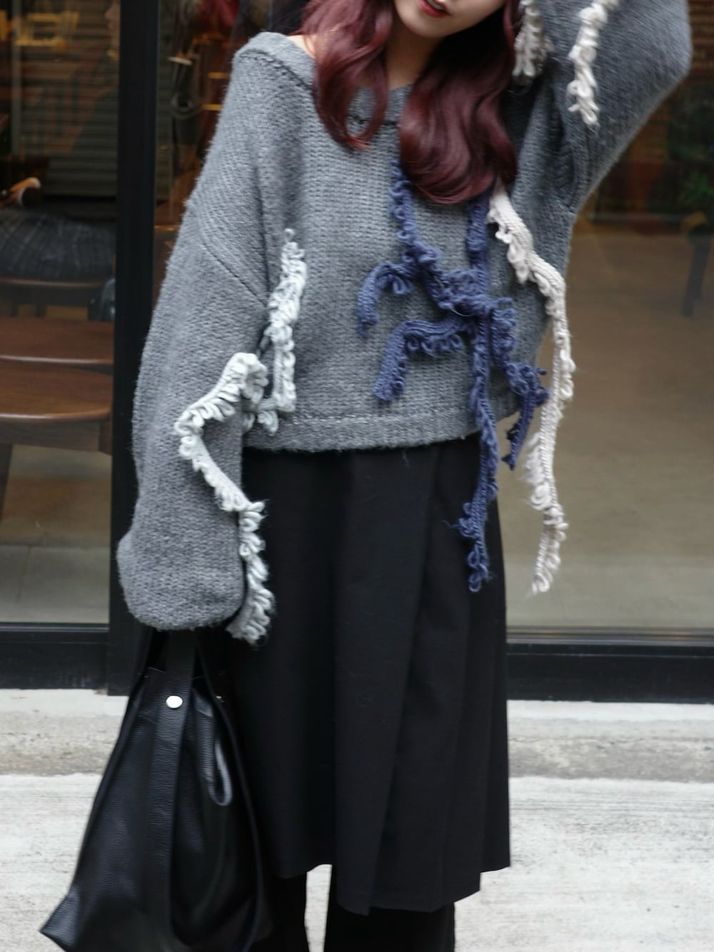 ブラック系のパンツ、ブラック系のショルダーバッグ、グレー系のニット/セーターを着用したレディースの秋コーディネートの2枚目の写真