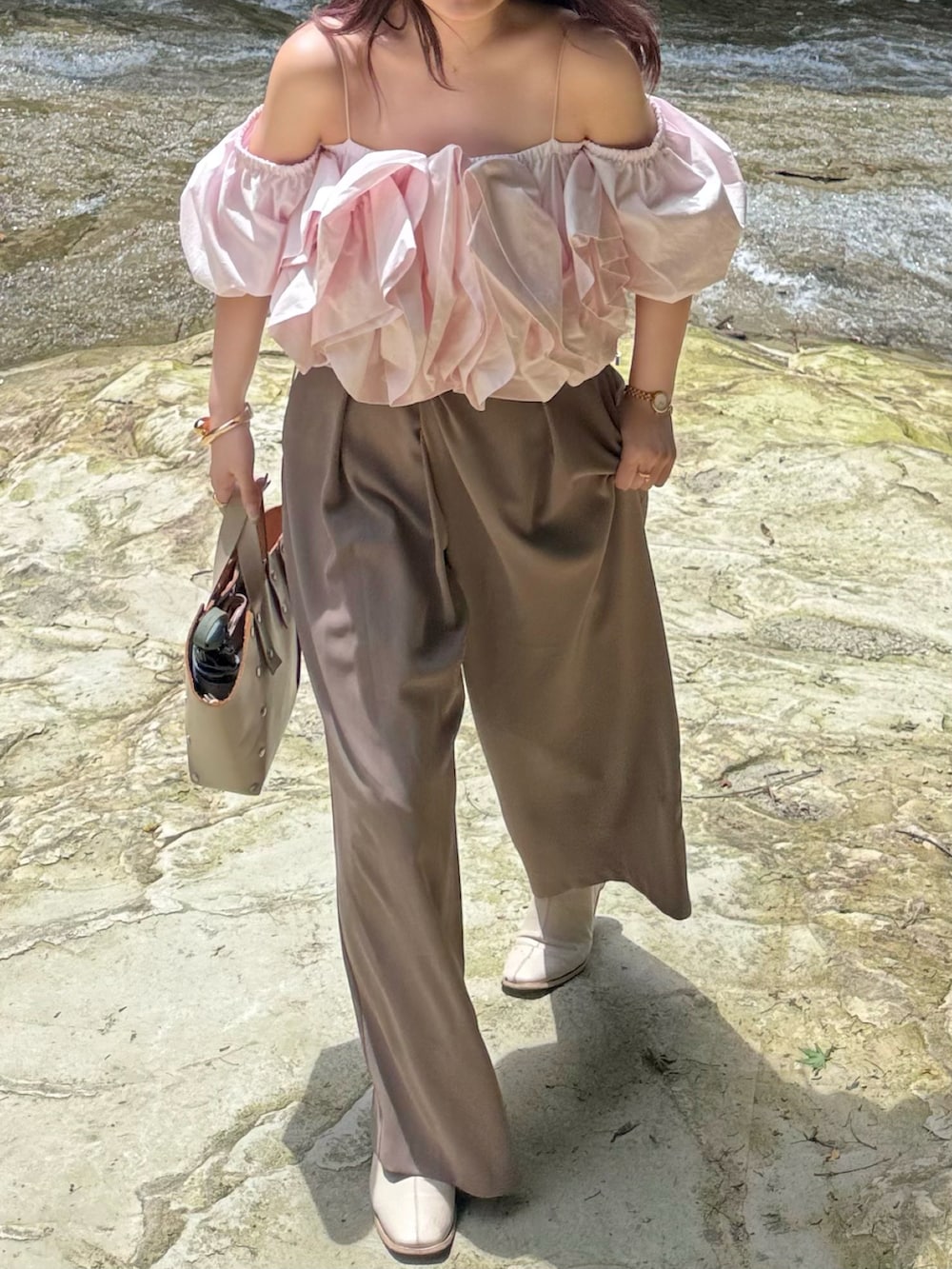 ベージュ系のハンドバッグ、ピンク系のシャツ/ブラウス、ブラウン系のパンツを着用したレディースの夏コーディネートの2枚目の写真