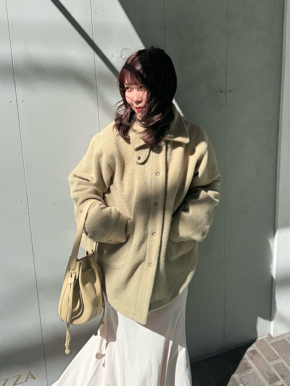 グリーン系のその他アウター、ベージュ系のショルダーバッグ、イエロー系のブーツを着用したレディースの春コーディネートの3枚目の写真