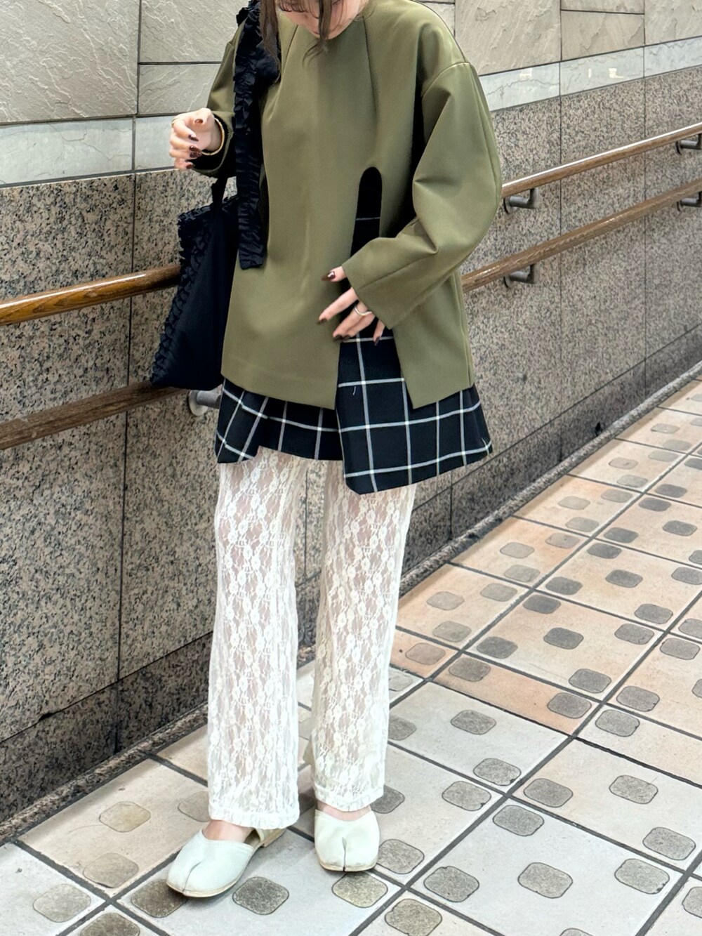 ブラック系のトートバッグ、ホワイト系のパンツ、ベージュ系のサンダルを着用したレディースの秋コーディネートの2枚目の写真