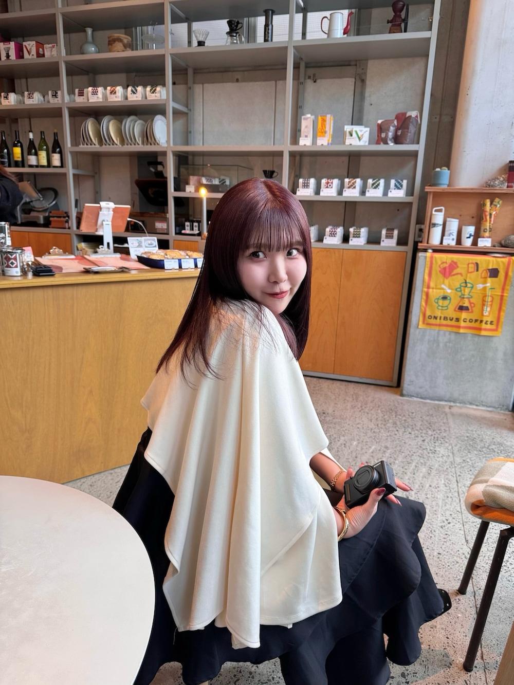 ベージュ系のトップス、ブラック系のスカート、ブラック系のパンプスを着用したレディースの春コーディネートの5枚目の写真