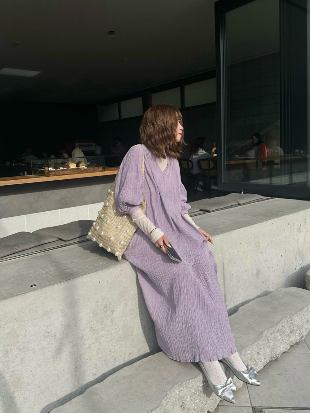 パープル系のワンピース、シルバー系のパンプス、ベージュ系のトートバッグを着用したレディースの夏コーディネートの3枚目の写真