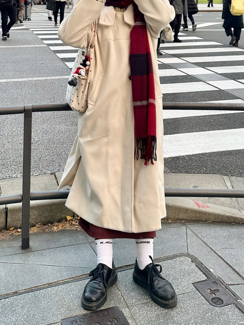 ブラック系のドレスシューズ、ホワイト系のその他アウター、ホワイト系のトートバッグを着用したレディースの冬コーディネートの2枚目の写真