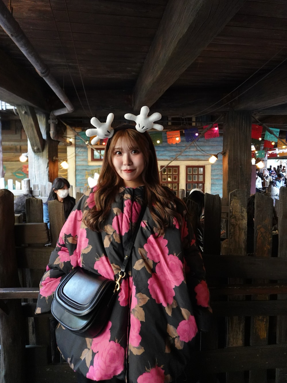 ブラック系のサロペット/オーバーオール、ピンク系のダウンジャケット/コート、シルバー系のローファーを着用したレディースの冬コーディネートの2枚目の写真