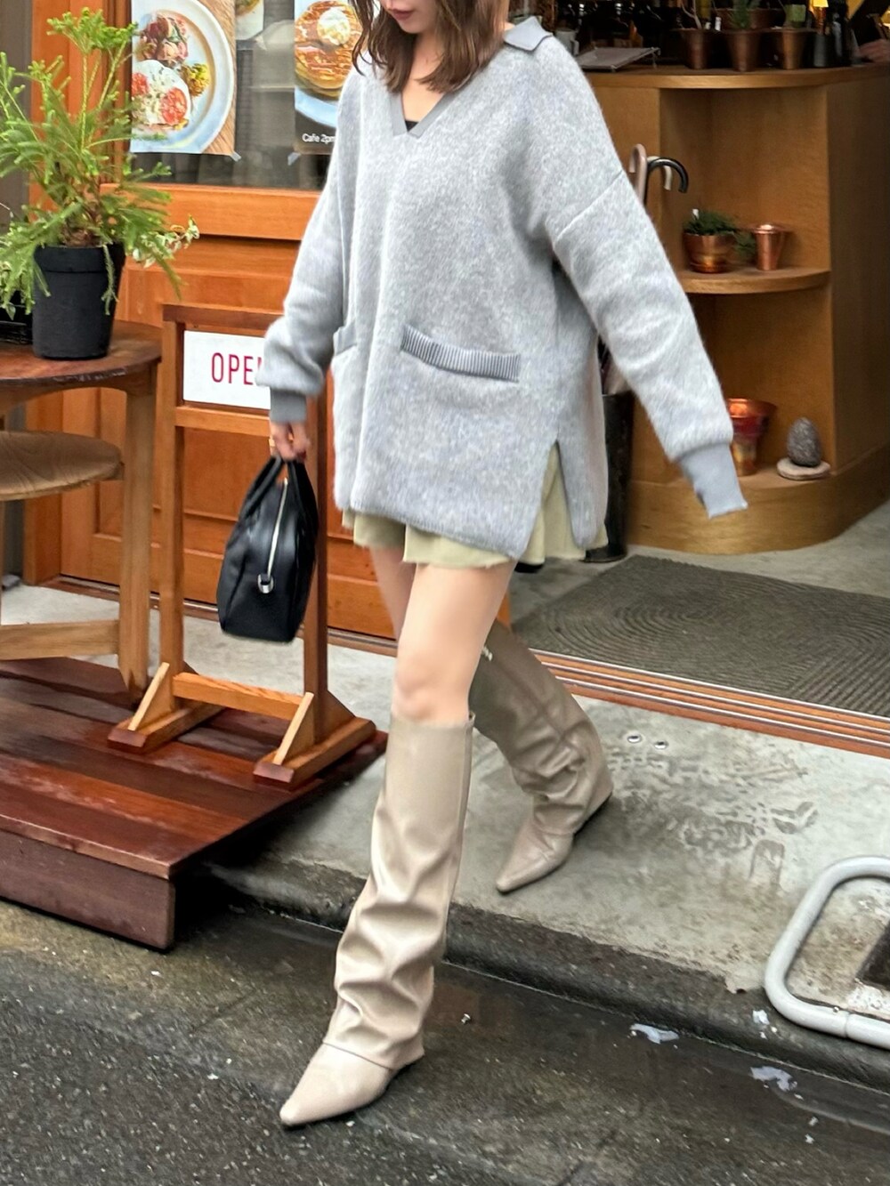 ベージュ系のブーツ、ブラック系のボストンバッグ、グレー系のニット/セーターを着用したレディースの秋コーディネートの4枚目の写真