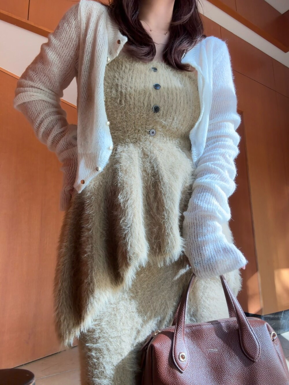 ブラウン系のボストンバッグ、ベージュ系のサンダル、ベージュ系のトップスを着用したレディースの秋コーディネートの2枚目の写真