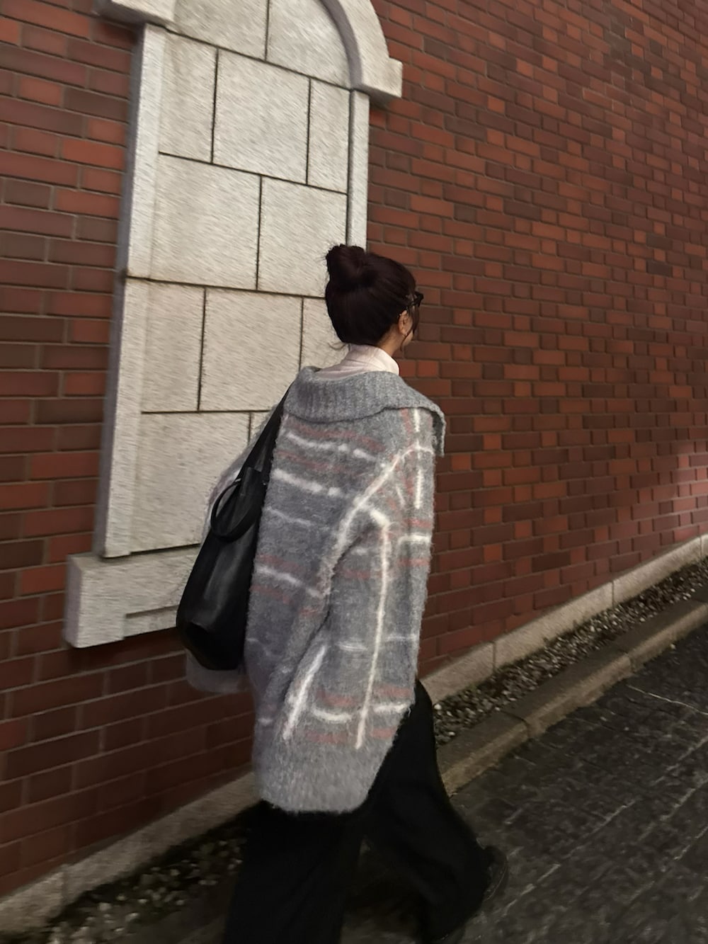 グレー系のニット/セーター、ブラック系のスラックスを着用したレディースの冬コーディネートの3枚目の写真