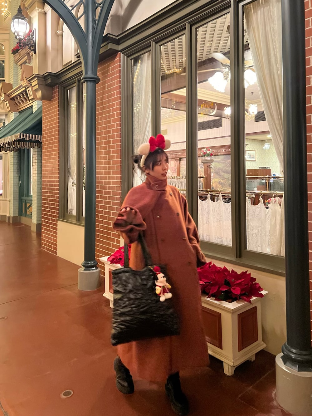 レッド系のジャケット/アウター、ブラック系のトートバッグ、ブラック系のブーツを着用したレディースの冬コーディネートの5枚目の写真