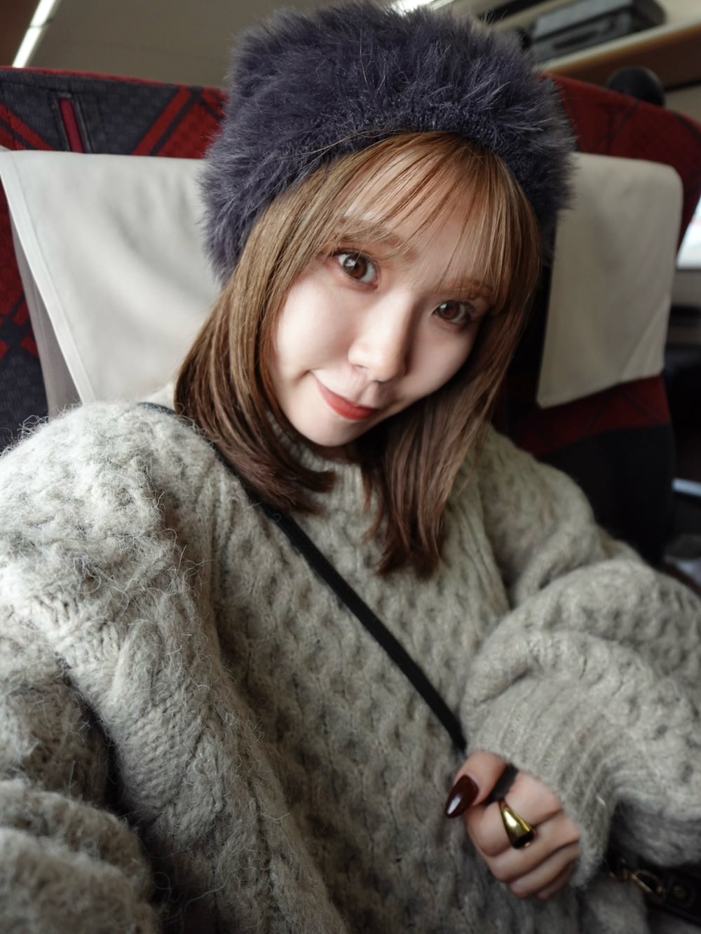 ブラウン系のニット/セーター、ブルー系のサロペット/オーバーオール、シルバー系のブーツを着用したレディースの秋コーディネートの5枚目の写真