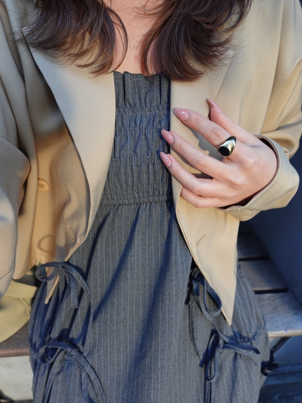 ベージュ系のテーラードジャケット、ブラック系のワンピース、ベージュ系のショルダーバッグを着用したレディースの春コーディネートの5枚目の写真