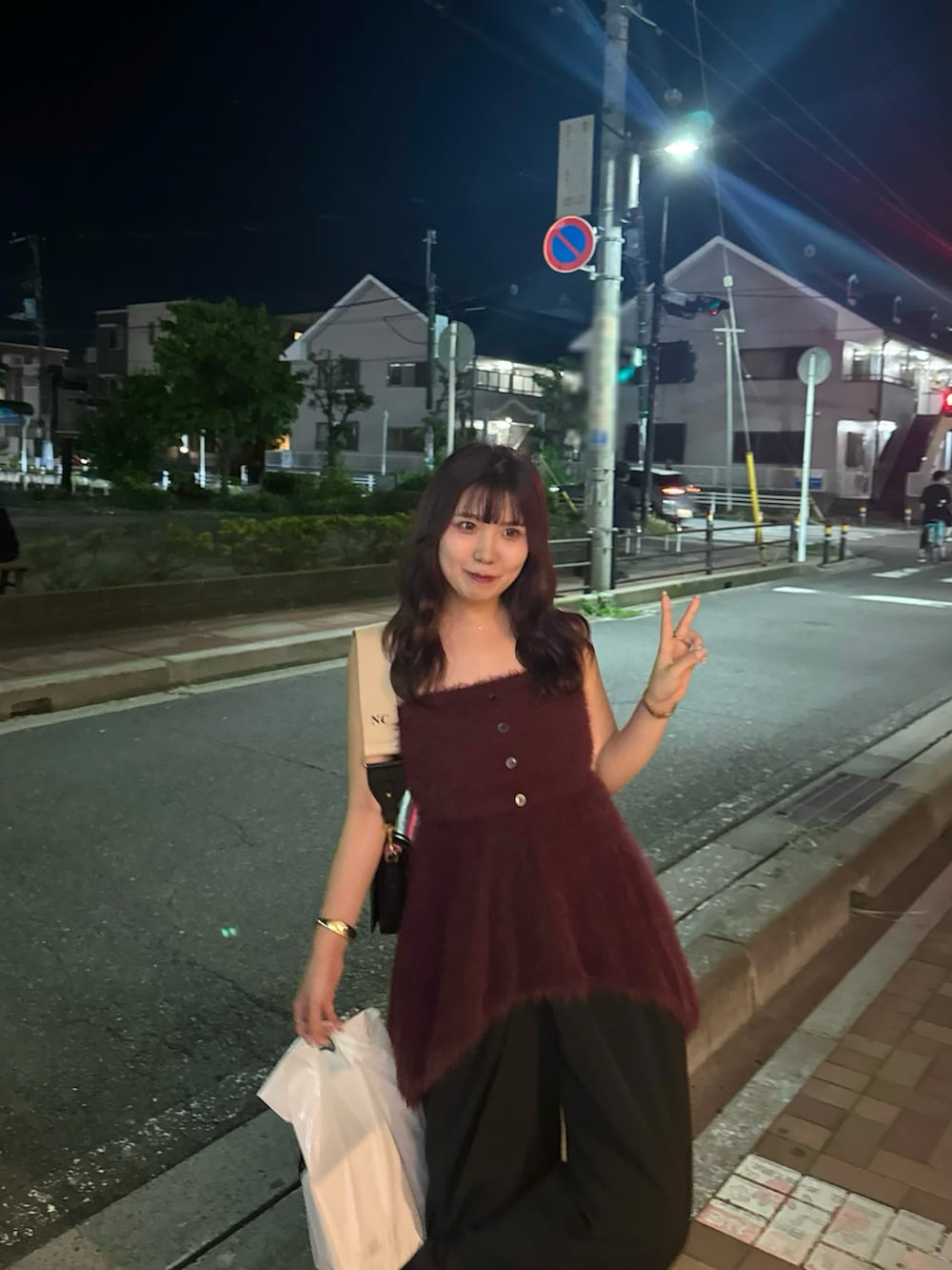 ブラック系のスラックス、レッド系のニット/セーターを着用したレディースの夏コーディネートの2枚目の写真