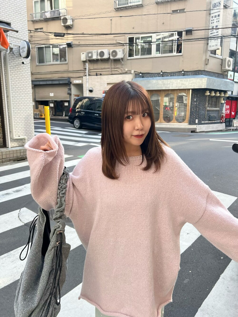 シルバー系のトートバッグ、シルバー系のパンプス、ブルー系のデニムパンツを着用したレディースの冬コーディネートの5枚目の写真