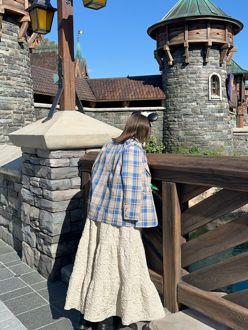 ベージュ系のワンピース、ブルー系のテーラードジャケットを着用したレディースの夏コーディネートの5枚目の写真