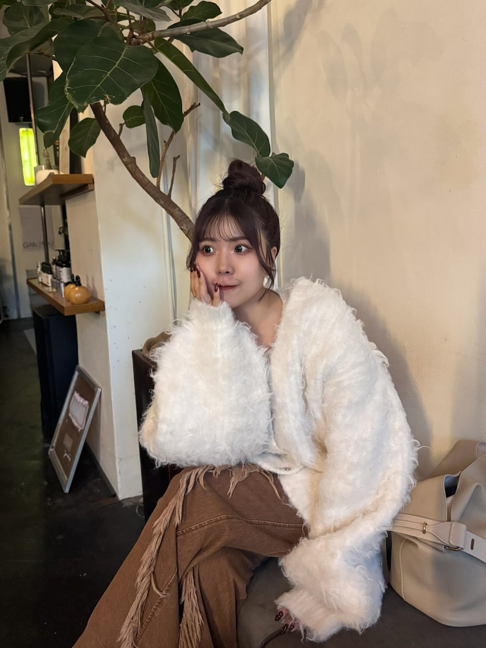 ホワイト系のニット/セーター、ブラウン系のデニムパンツ、シルバー系のローファーを着用したレディースの秋コーディネートの4枚目の写真