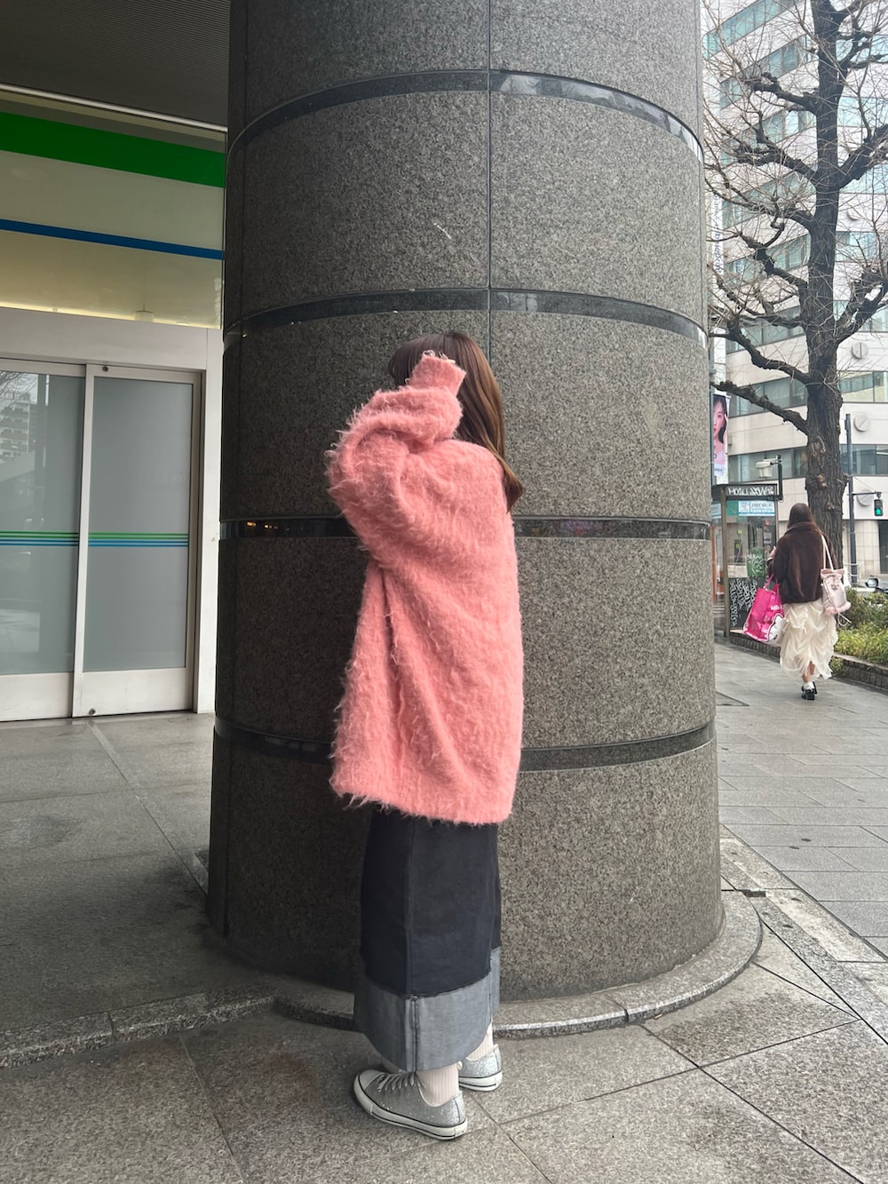 ピンク系のカーディガン/ボレロ、グレー系のTシャツ/カットソー、ブラック系のデニムスカートを着用したレディースの冬コーディネートの2枚目の写真