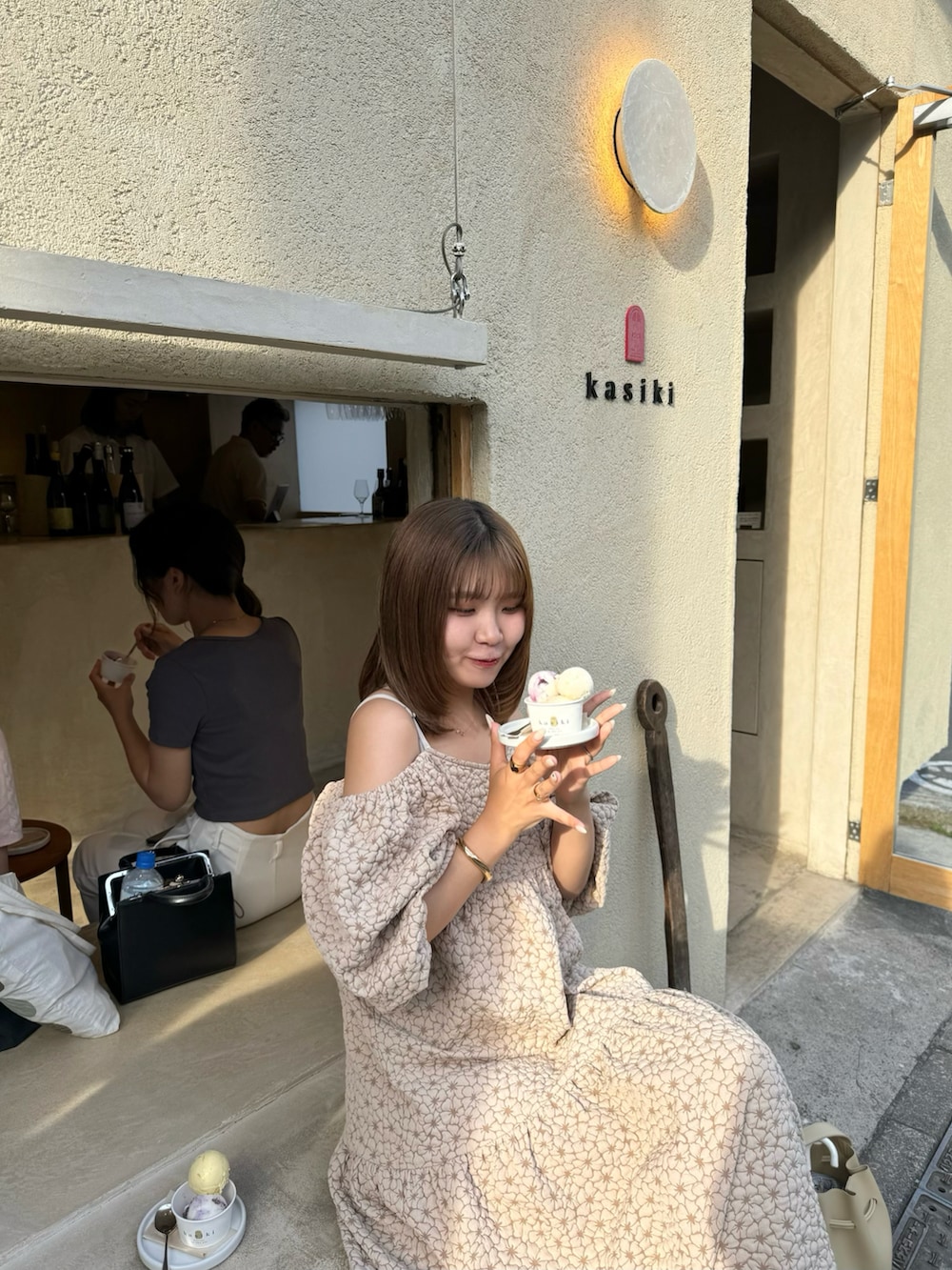 ホワイト系のワンピース、ベージュ系のショルダーバッグ、ブラック系のサンダルを着用したレディースの夏コーディネートの5枚目の写真