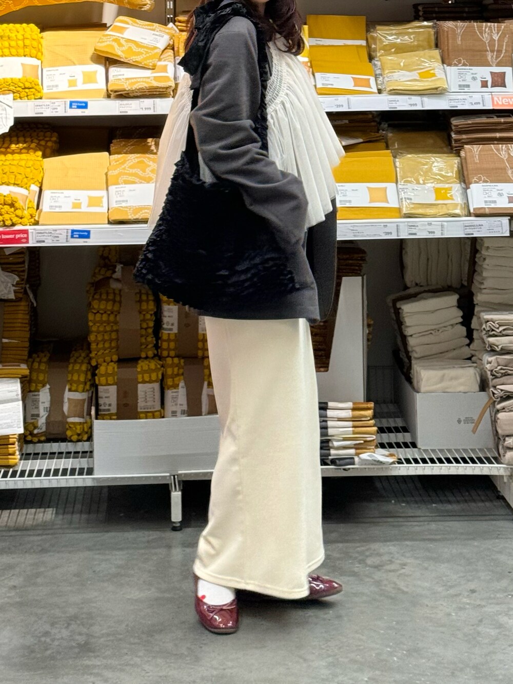 ホワイト系のチューブトップ、ブラック系のトートバッグ、ホワイト系のスカートを着用したレディースの春コーディネートの2枚目の写真