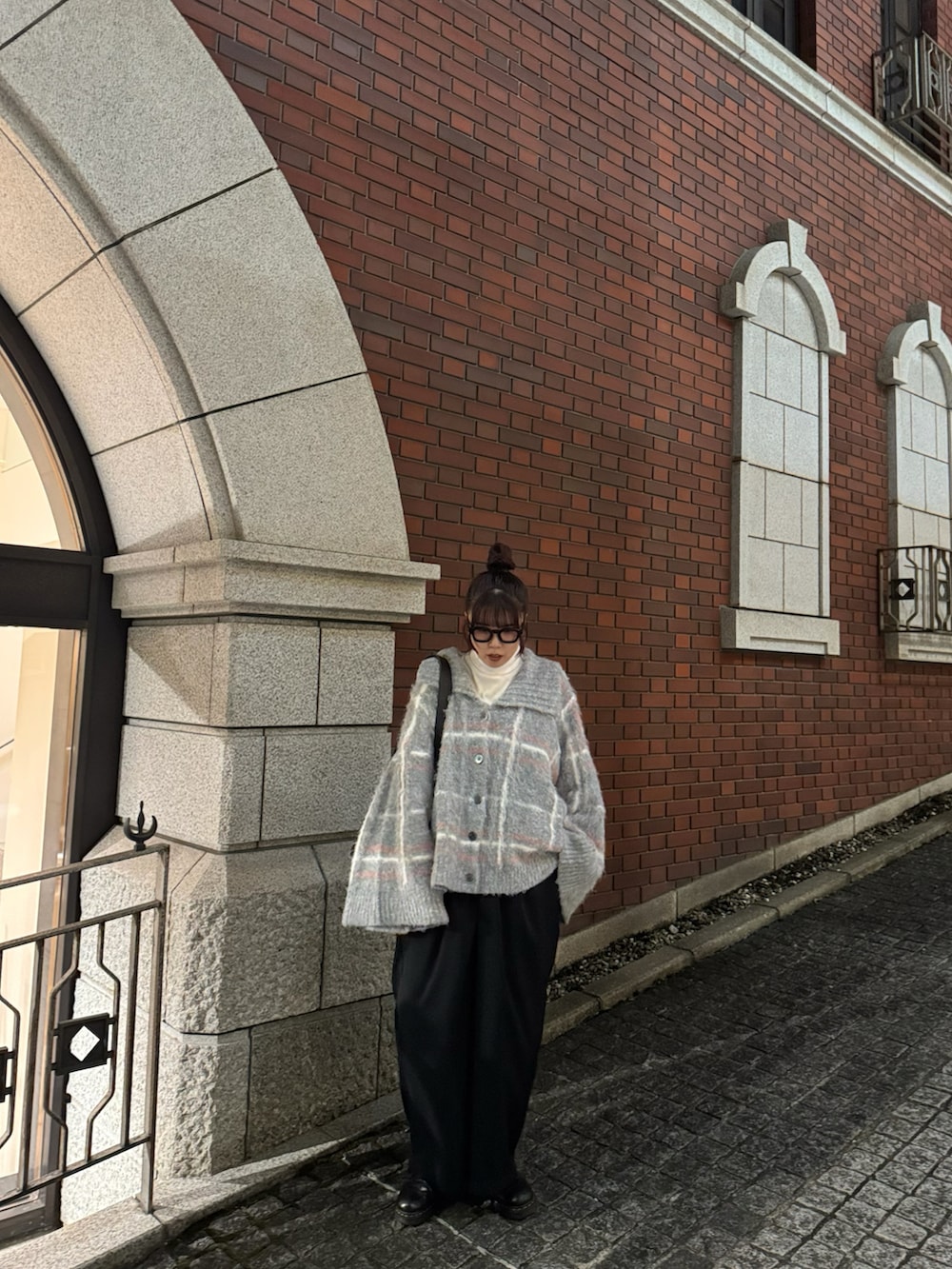 グレー系のニット/セーター、ブラック系のスラックスを着用したレディースの冬コーディネートの2枚目の写真