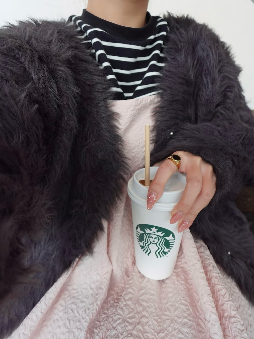 ピンク系のワンピース、ブラック系のパンプス、ブラック系のニット/セーターを着用したレディースの春コーディネートの3枚目の写真