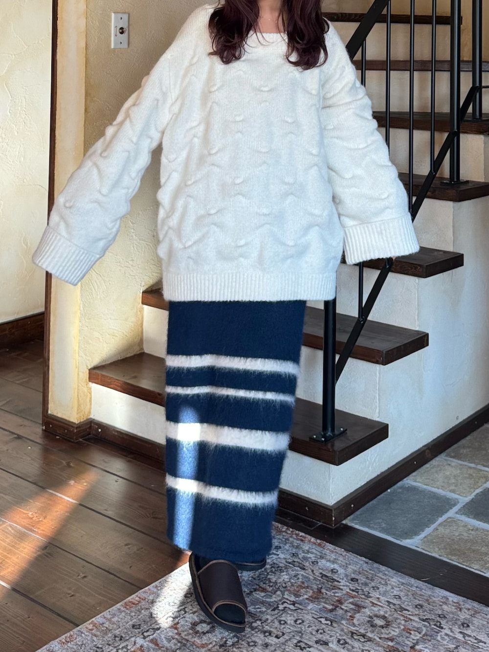 ホワイト系のニット/セーター、ブルー系のスカートを着用したレディースの冬コーディネートの2枚目の写真