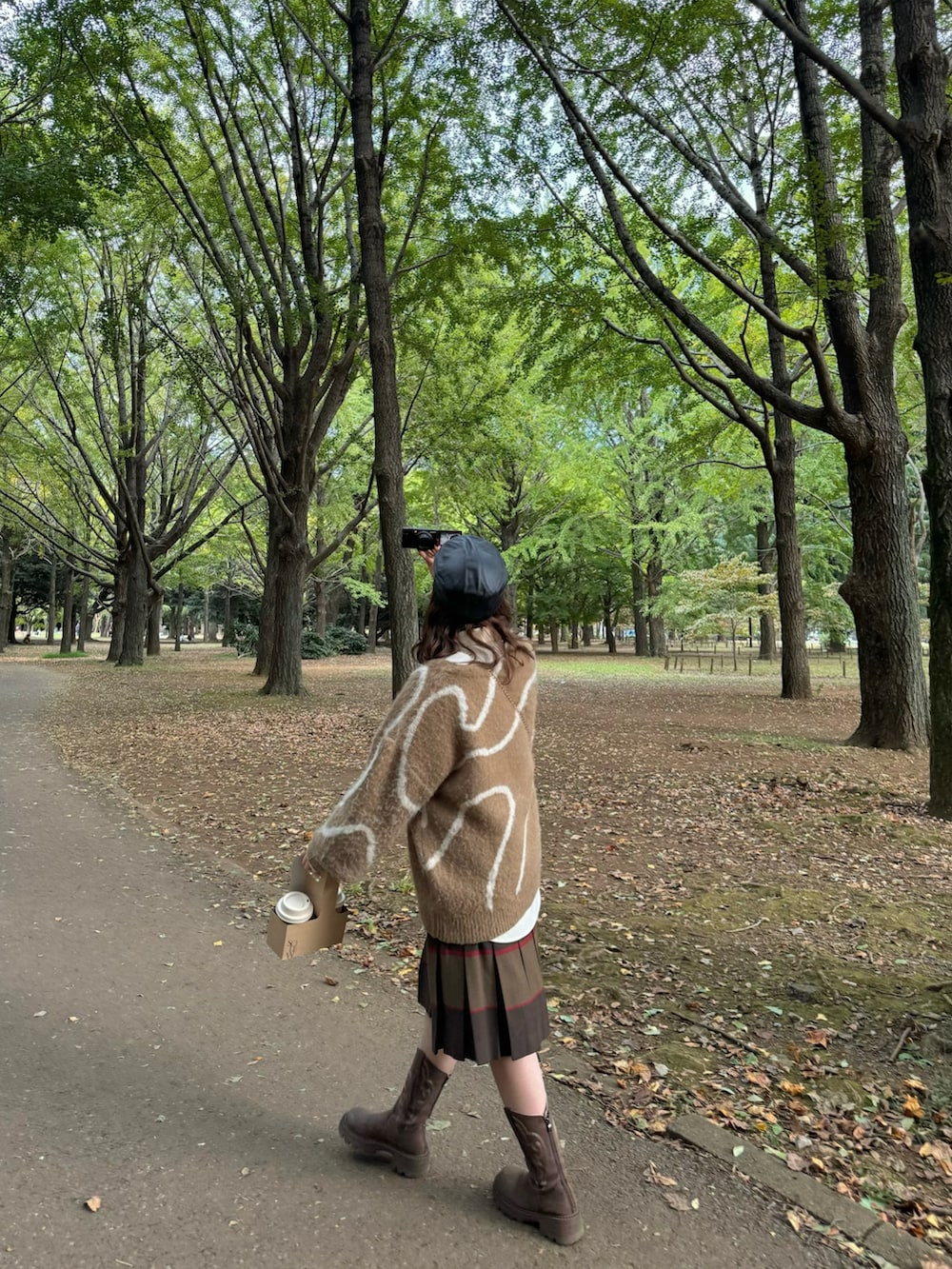 ブラウン系のニット/セーター、ブラウン系のスカート、ベージュ系のシャツ/ブラウスを着用したレディースの秋コーディネートの3枚目の写真