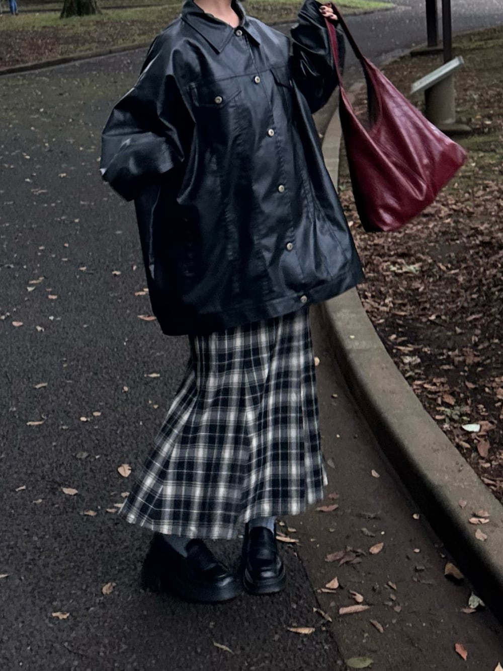 ブラック系のブルゾン、ブラック系のシューズ、ブラック系のスカートを着用したレディースの秋コーディネートの2枚目の写真