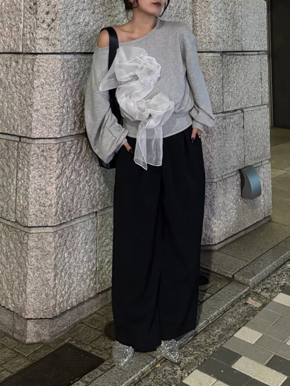 ブラック系のスラックス、グレー系のスウェット、ブラック系のショルダーバッグを着用したレディースの秋コーディネートの3枚目の写真