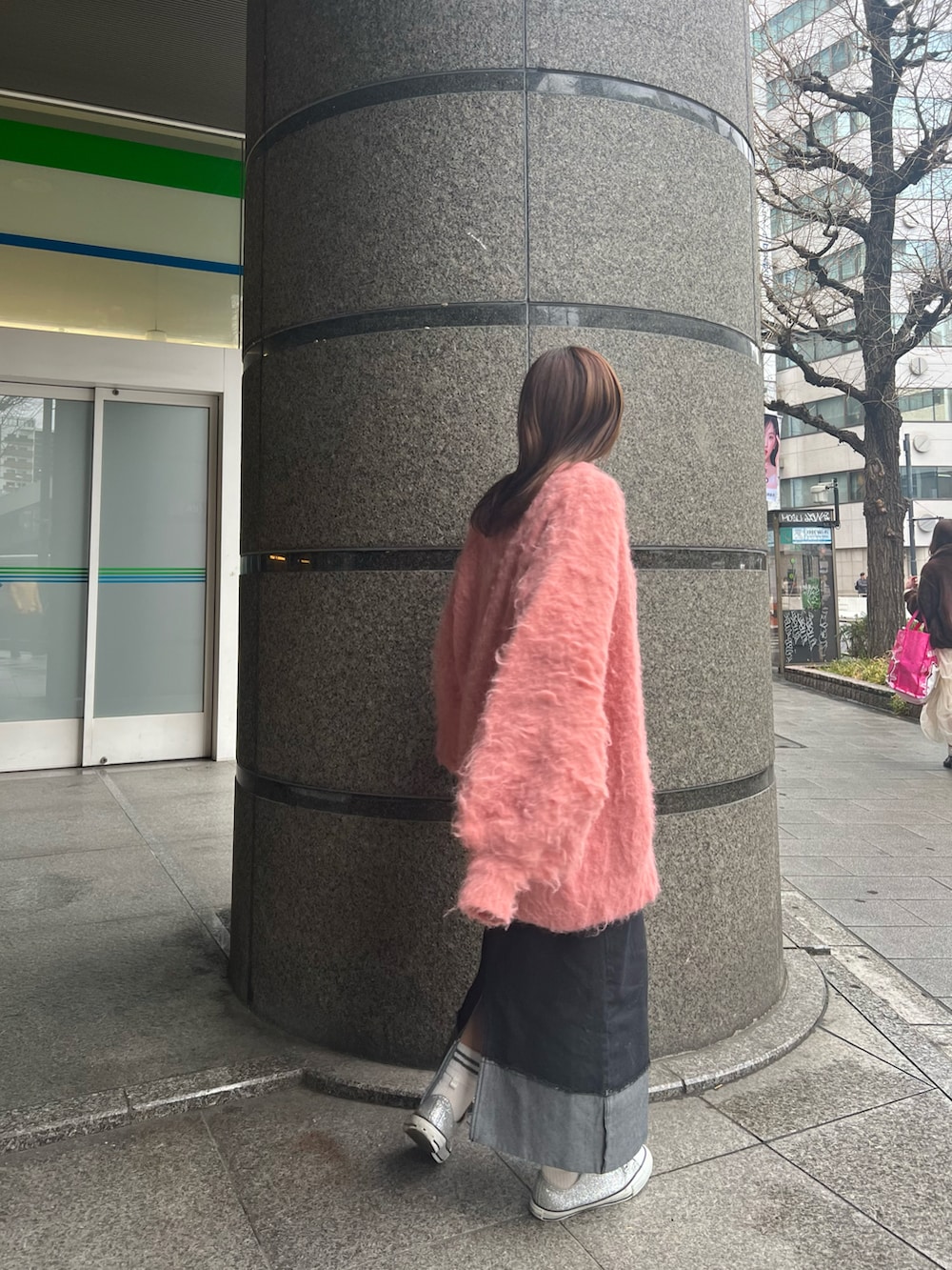 ピンク系のカーディガン/ボレロ、グレー系のTシャツ/カットソー、ブラック系のデニムスカートを着用したレディースの冬コーディネートの3枚目の写真