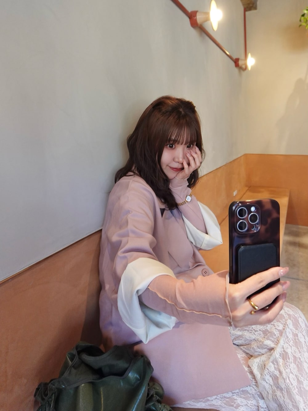 ピンク系のテーラードジャケット、ホワイト系のブーツ、グリーン系のショルダーバッグを着用したレディースの春コーディネートの4枚目の写真