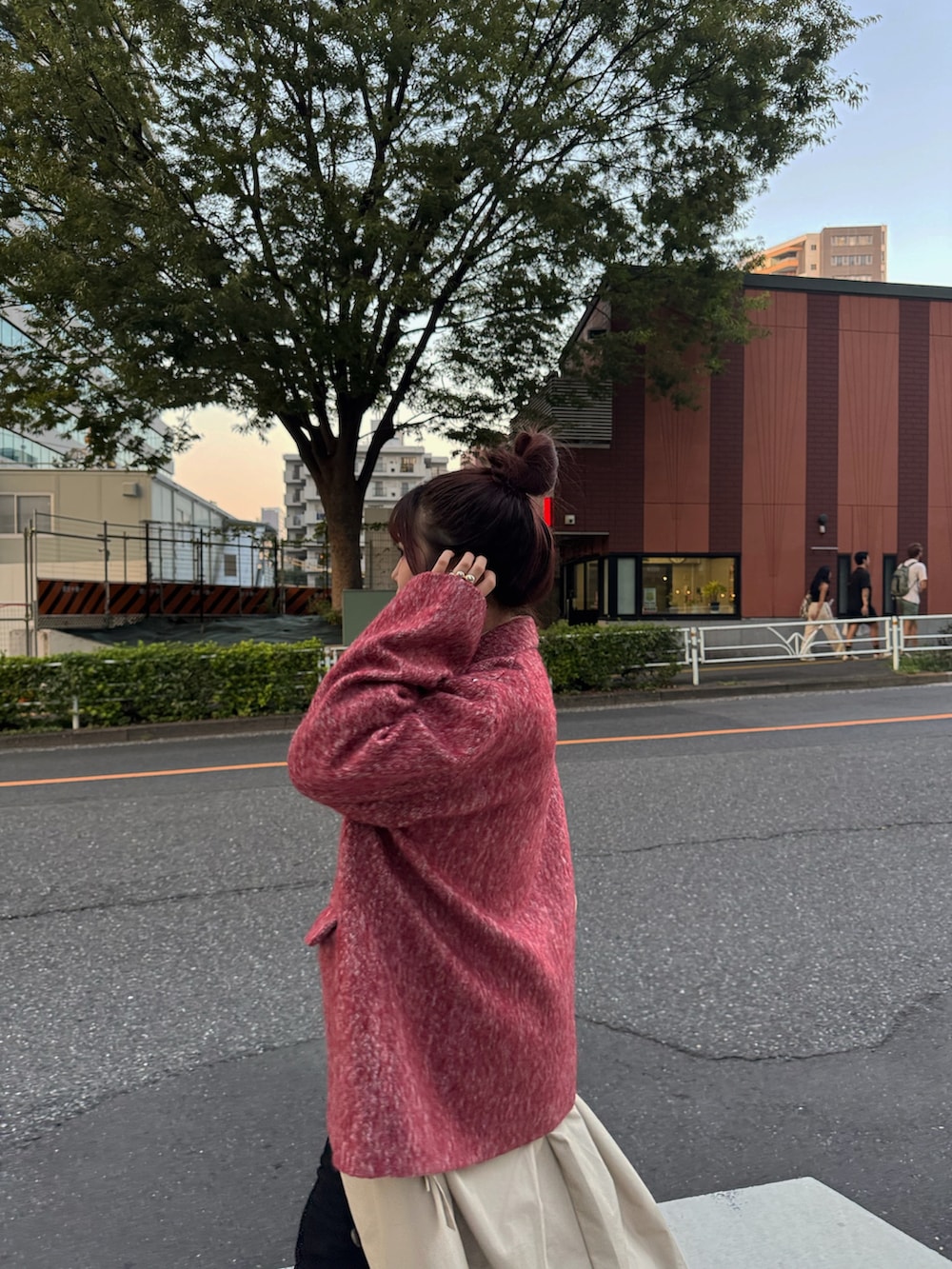 ベージュ系のステンカラーコート、ブラック系のブーツ、ベージュ系のショルダーバッグを着用したレディースの秋コーディネートの5枚目の写真