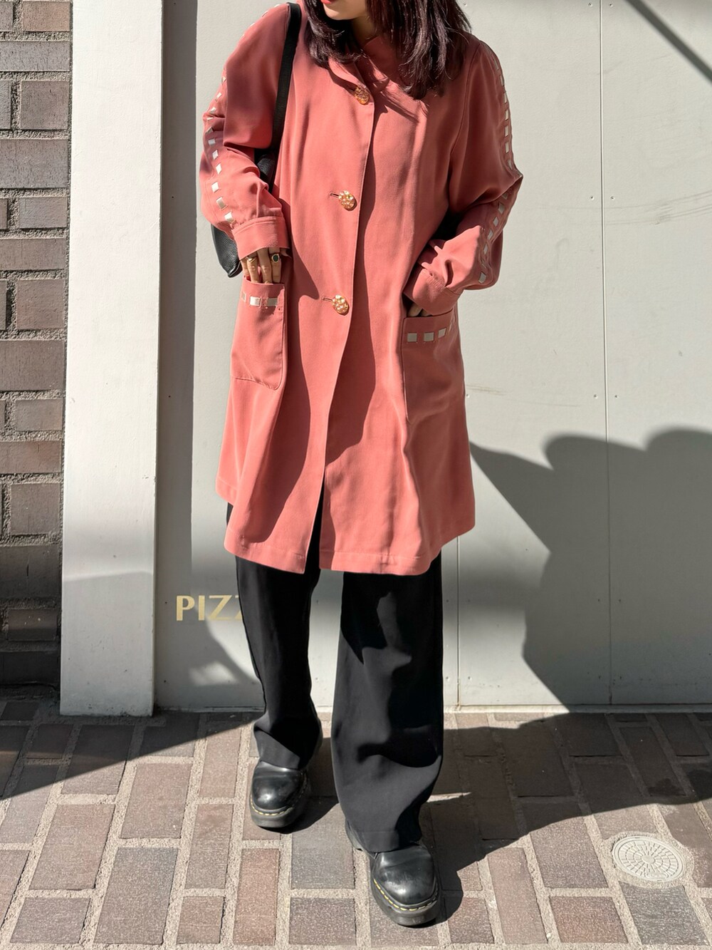 ブラック系のドレスシューズ、ピンク系のトップス、ブラック系のスラックスを着用したレディースの春コーディネートの2枚目の写真