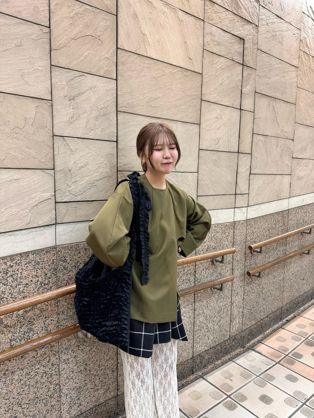 ブラック系のトートバッグ、ホワイト系のパンツ、ベージュ系のサンダルを着用したレディースの秋コーディネートの5枚目の写真