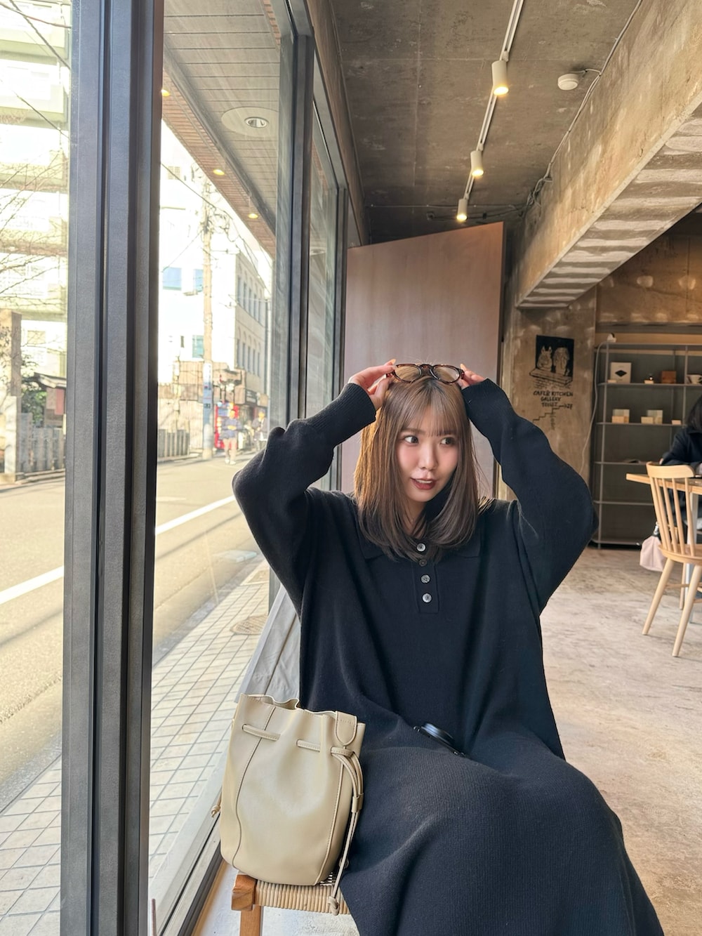 ベージュ系のショルダーバッグ、ベージュ系のステンカラーコート、ブラック系のワンピースを着用したレディースの冬コーディネートの4枚目の写真