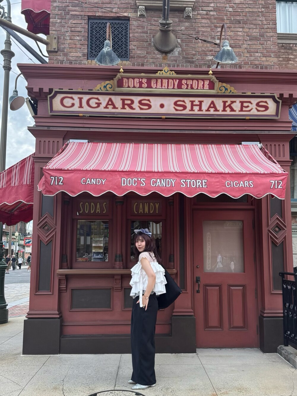 ブラック系のスラックス、シルバー系のローファー、ホワイト系のシャツ/ブラウスを着用したレディースの夏コーディネートの4枚目の写真