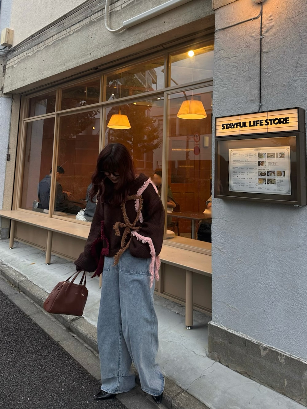 ブラック系のパンプス、ブラウン系のボストンバッグ、ブラウン系のニット/セーターを着用したレディースの秋コーディネートの3枚目の写真