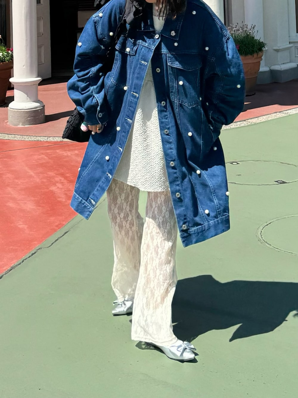 ブルー系のデニムジャケット、ホワイト系のパンツ、シルバー系のパンプスを着用したレディースの夏コーディネートの2枚目の写真