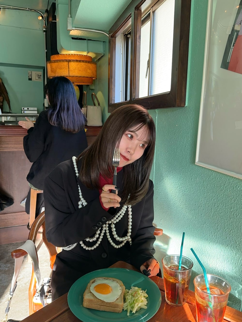 ブラック系のショルダーバッグ、ブラック系のブーツ、ブラック系のデニムパンツを着用したレディースの冬コーディネートの4枚目の写真