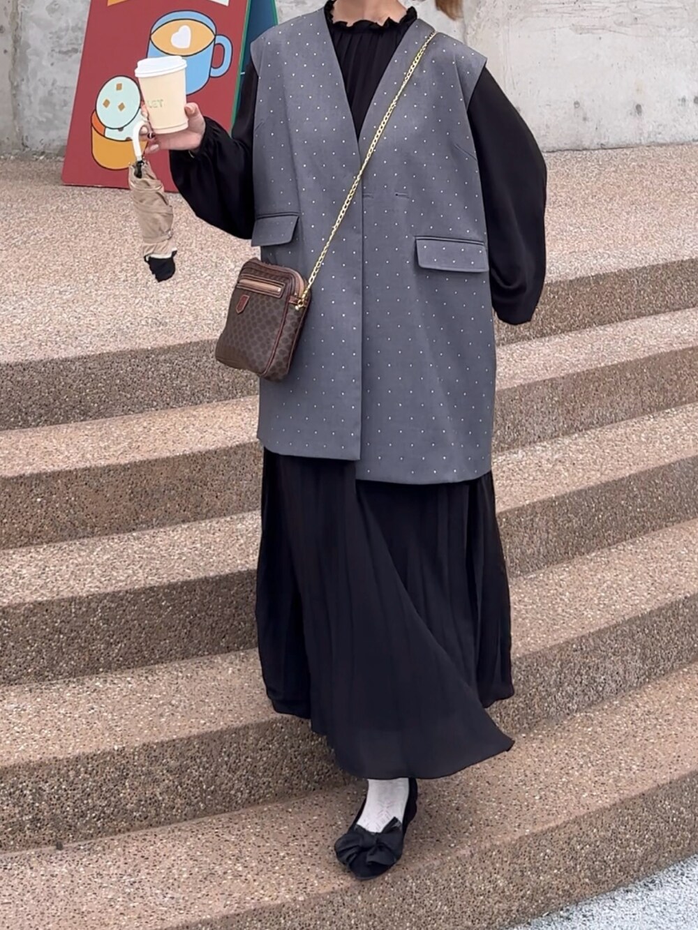 グレー系のベスト、ブラック系のワンピース/ドレスを着用したレディースの夏コーディネートの3枚目の写真