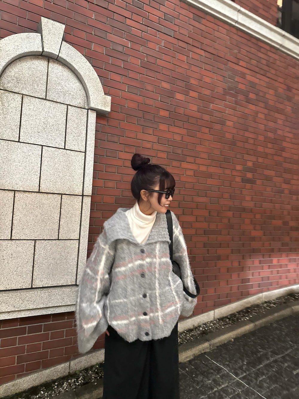 グレー系のニット/セーター、ブラック系のスラックスを着用したレディースの冬コーディネートの4枚目の写真