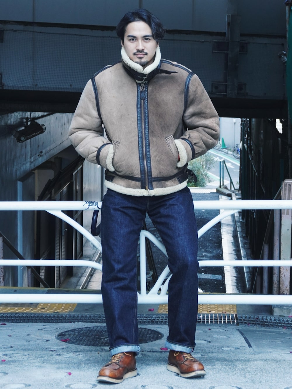 ブルー系のデニムパンツ、レッド系のブーツ、オレンジ系のスウェットを着用したメンズの冬コーディネートの2枚目の写真