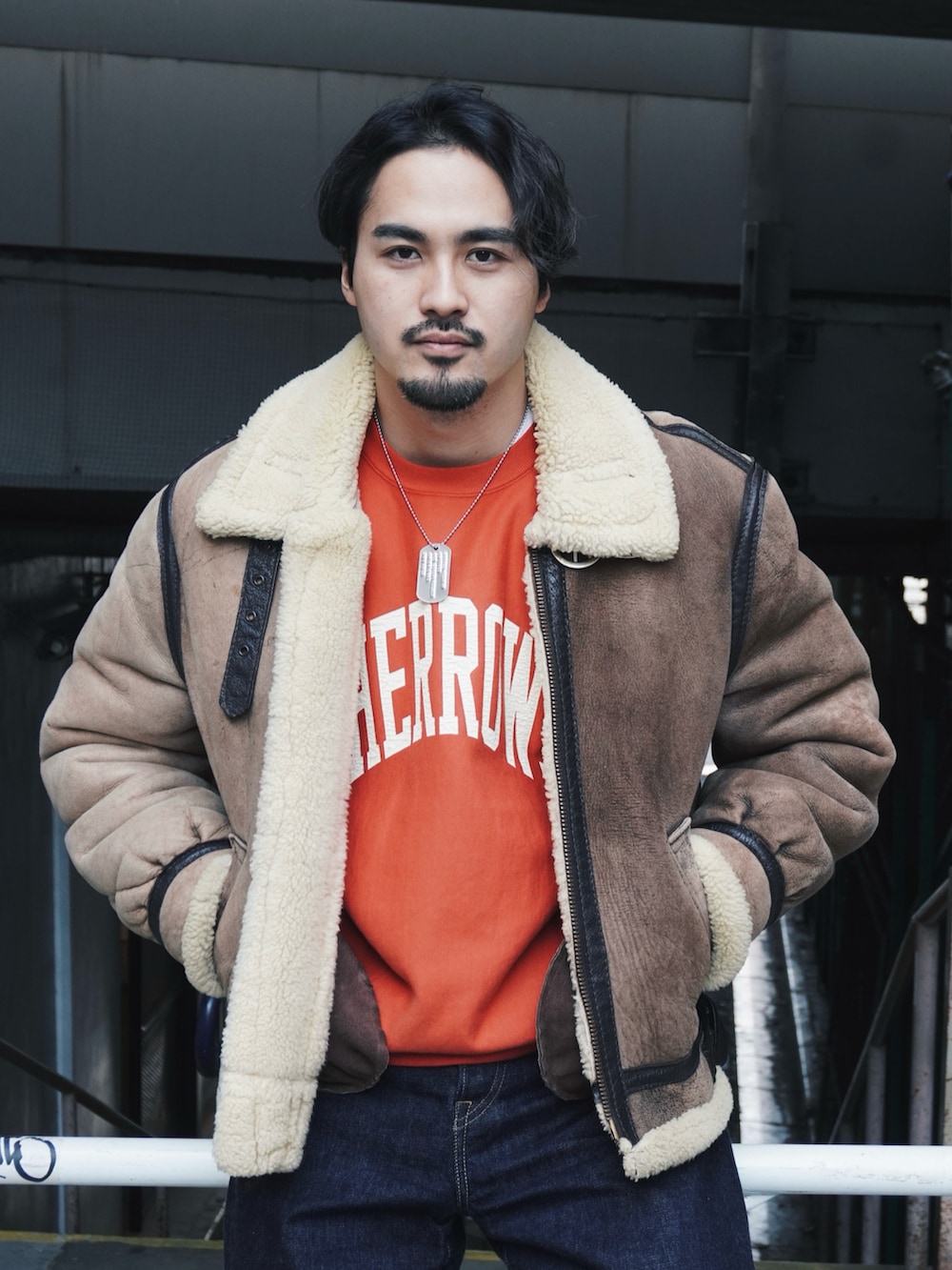 ブルー系のデニムパンツ、レッド系のブーツ、オレンジ系のスウェットを着用したメンズの冬コーディネートの3枚目の写真