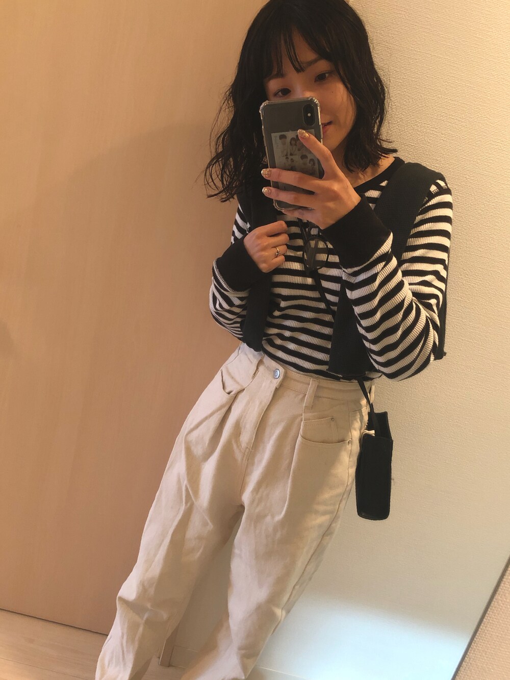 ブラック系のTシャツ/カットソー、ブラック系のカーディガン/ボレロ、ベージュ系のパンツを着用したレディースの春コーディネートの2枚目の写真