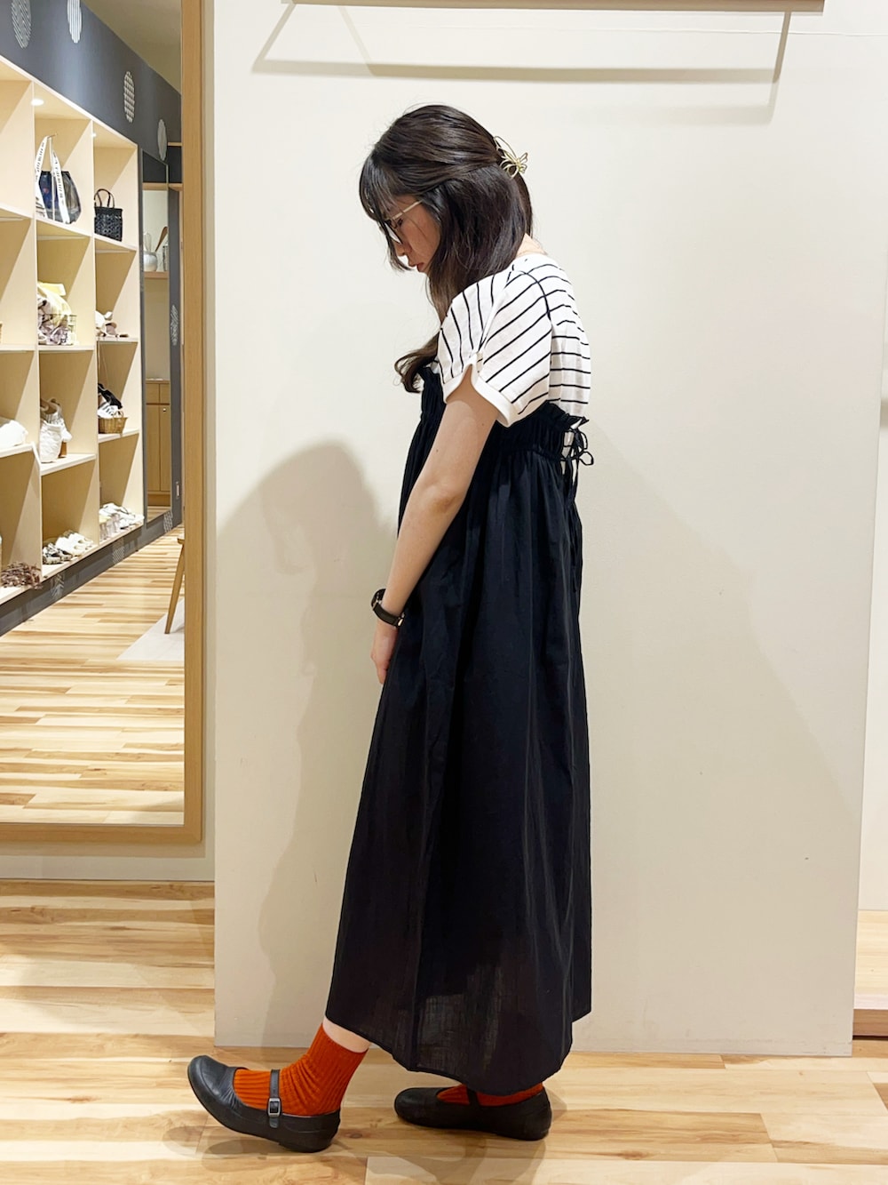 ブラック系のブーツ、ブラック系のワンピース、ブラック系のTシャツ/カットソーを着用したレディースの夏コーディネートの3枚目の写真